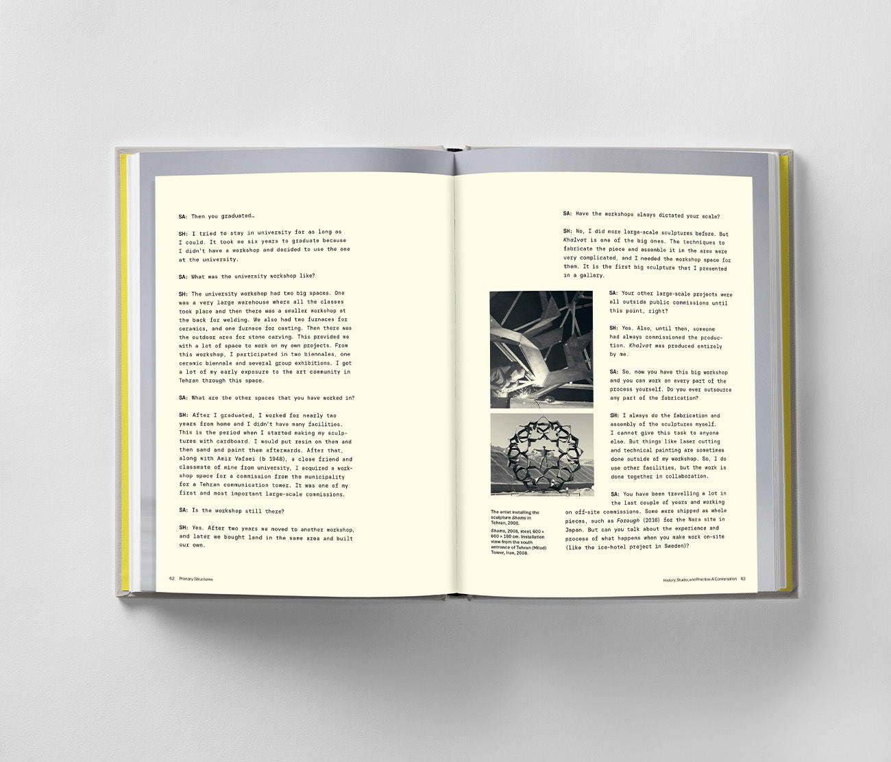 Open "Sahand Hesamiyan: Primary Structures" by Black Dog Online on a light surface, revealing pages with text and two black-and-white photos—one depicting an architectural facade inspired by Islamic and Persian design, the other showcasing Sahand Hesamiyan's complex geometric form.