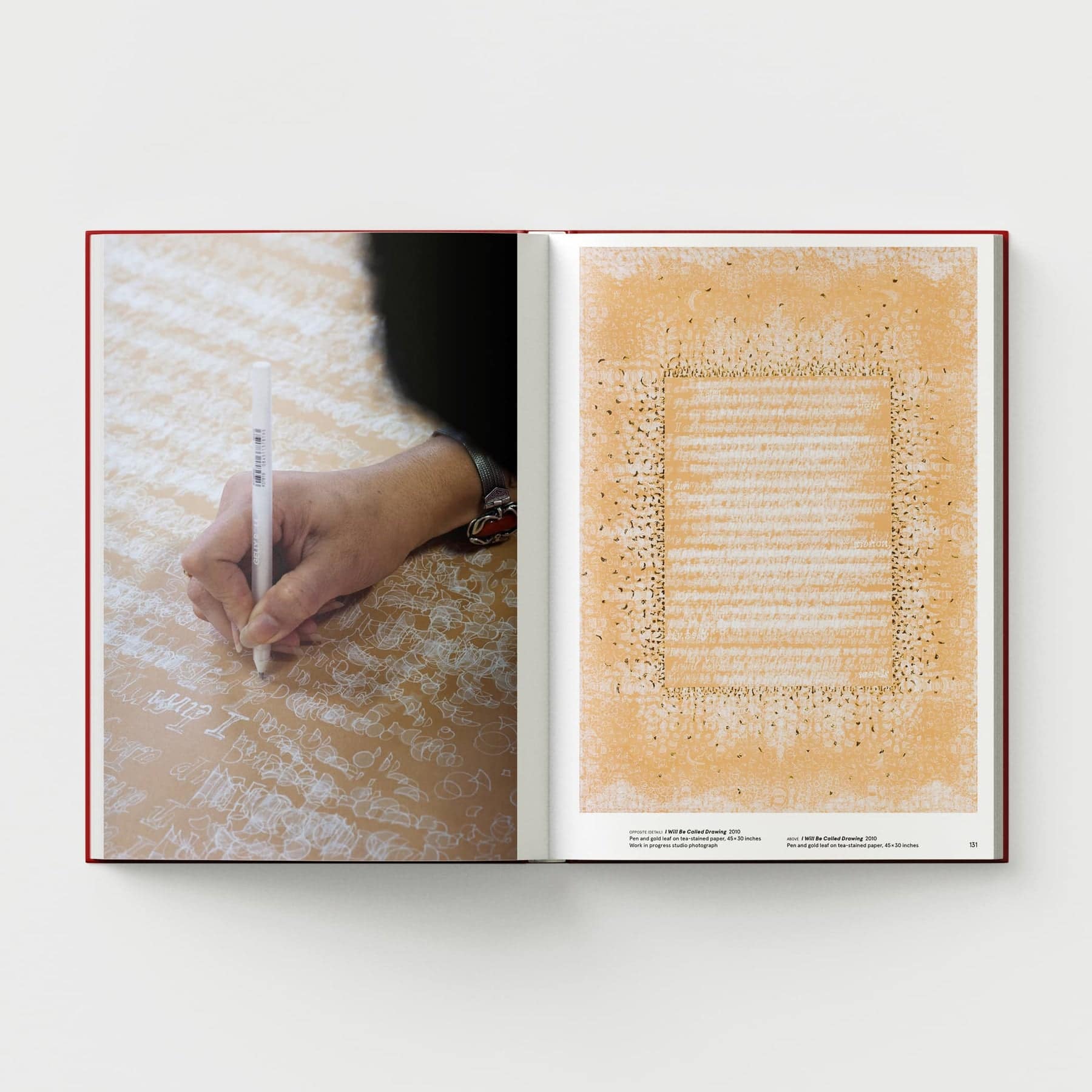 An open copy of *Ambreen Butt: What Comes to My Lips* by Black Dog Online sits on the table, revealing a hand writing with a white pen on pages adorned with script and elegant Indo-Persian miniature paintings, echoing intricate patterns reminiscent of civil liberties.