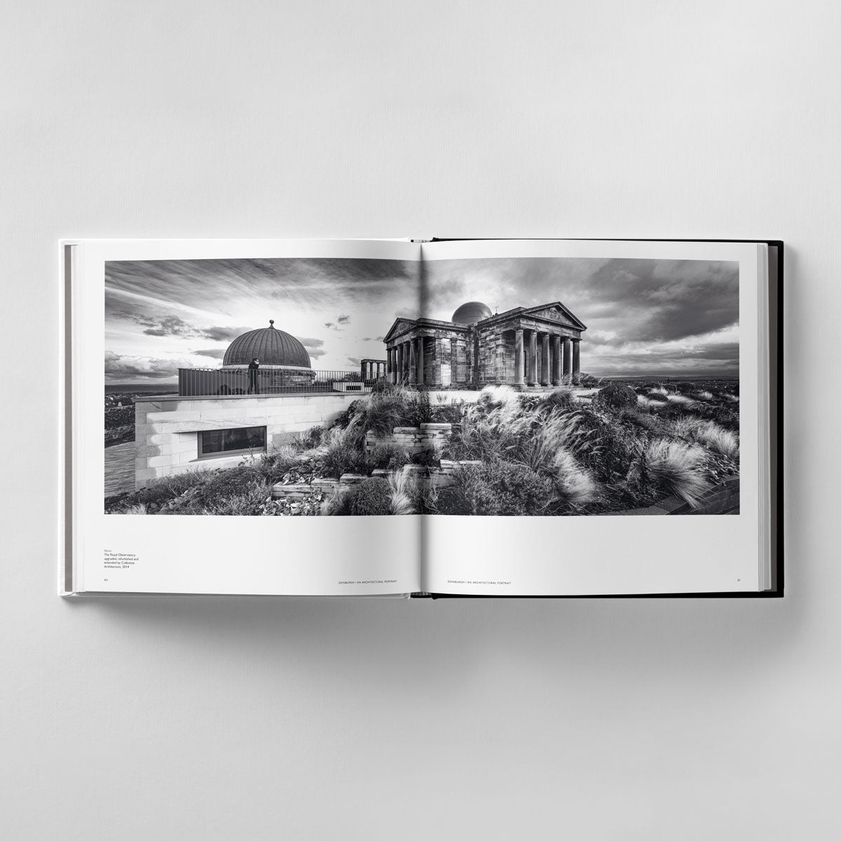 In "Edinburgh: An Architectural Portrait" by Black Dog Online, an open page showcases a black-and-white photo by James Reid, depicting an observatory and a classical-style building set in a grassy landscape.