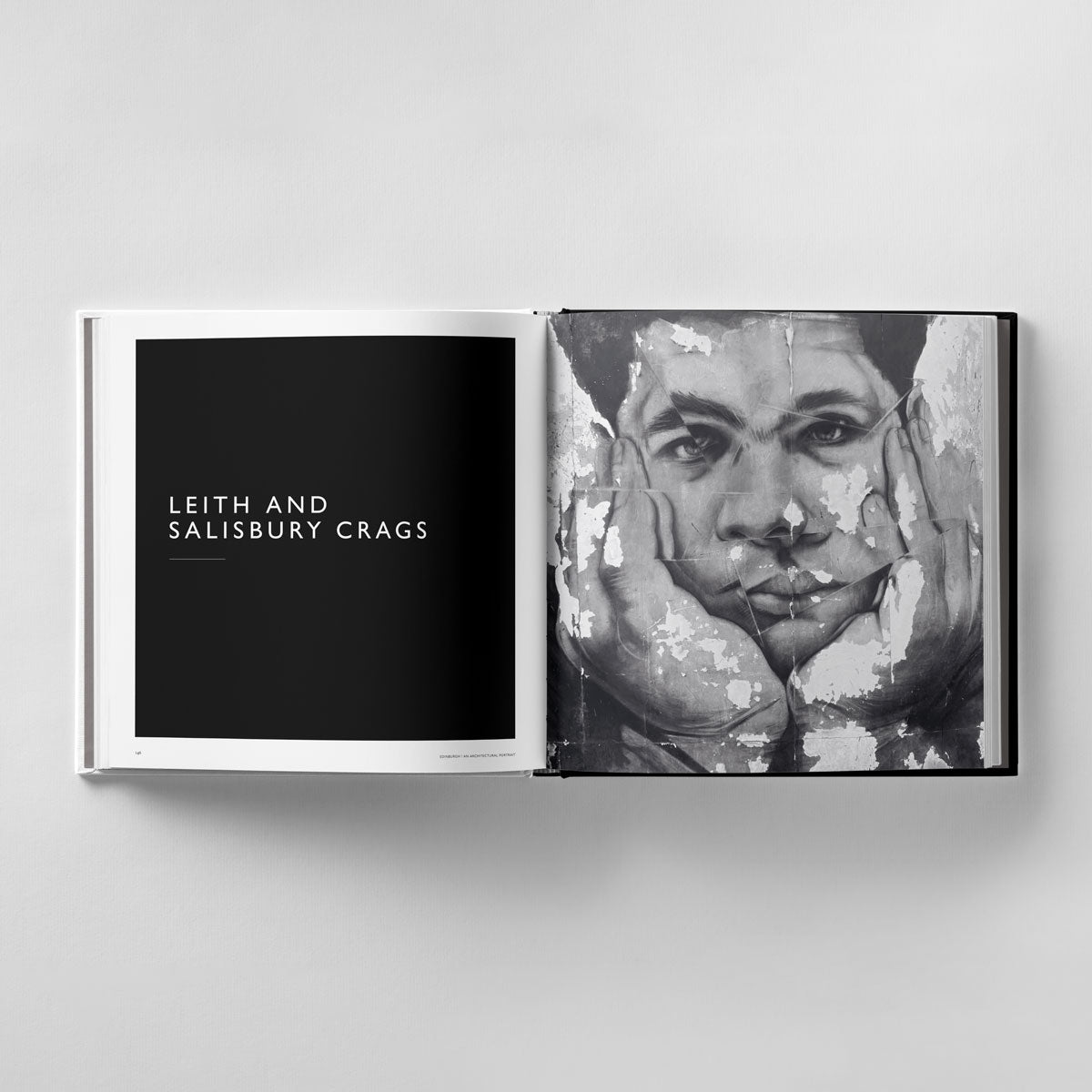 Open on a table is "Edinburgh: An Architectural Portrait" by Black Dog Online, showing "Leith and Salisbury Crags" on the left page and a grayscale painting of a face with hands on cheeks, echoing the depth seen in James Reid's architectural photography.
