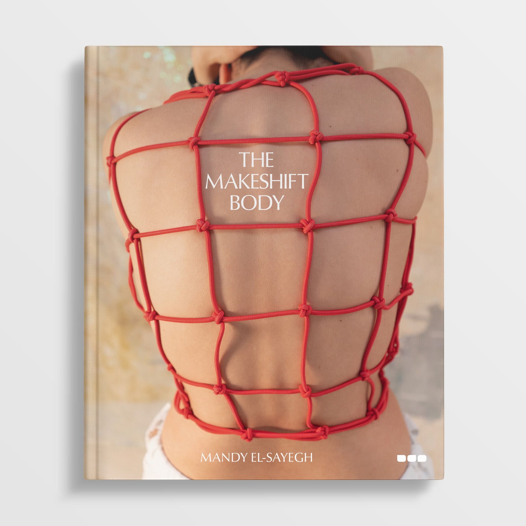The book cover features a person with a red rope grid across their back, reflecting the distinctive style of contemporary artist Mandy El-Sayegh. Titled "The Makeshift Body: Mandy El-Sayegh," this monograph, published by Black Dog Online, explores themes of identity and transformation.