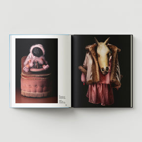 Open book from Black Dog Press titled "Formula + Fetish": left page shows a costumed figure on a vintage chair; right page features Mark Woods' work—a headless mannequin in pink, horse skull, and fur coat merging jewellery and fine art.