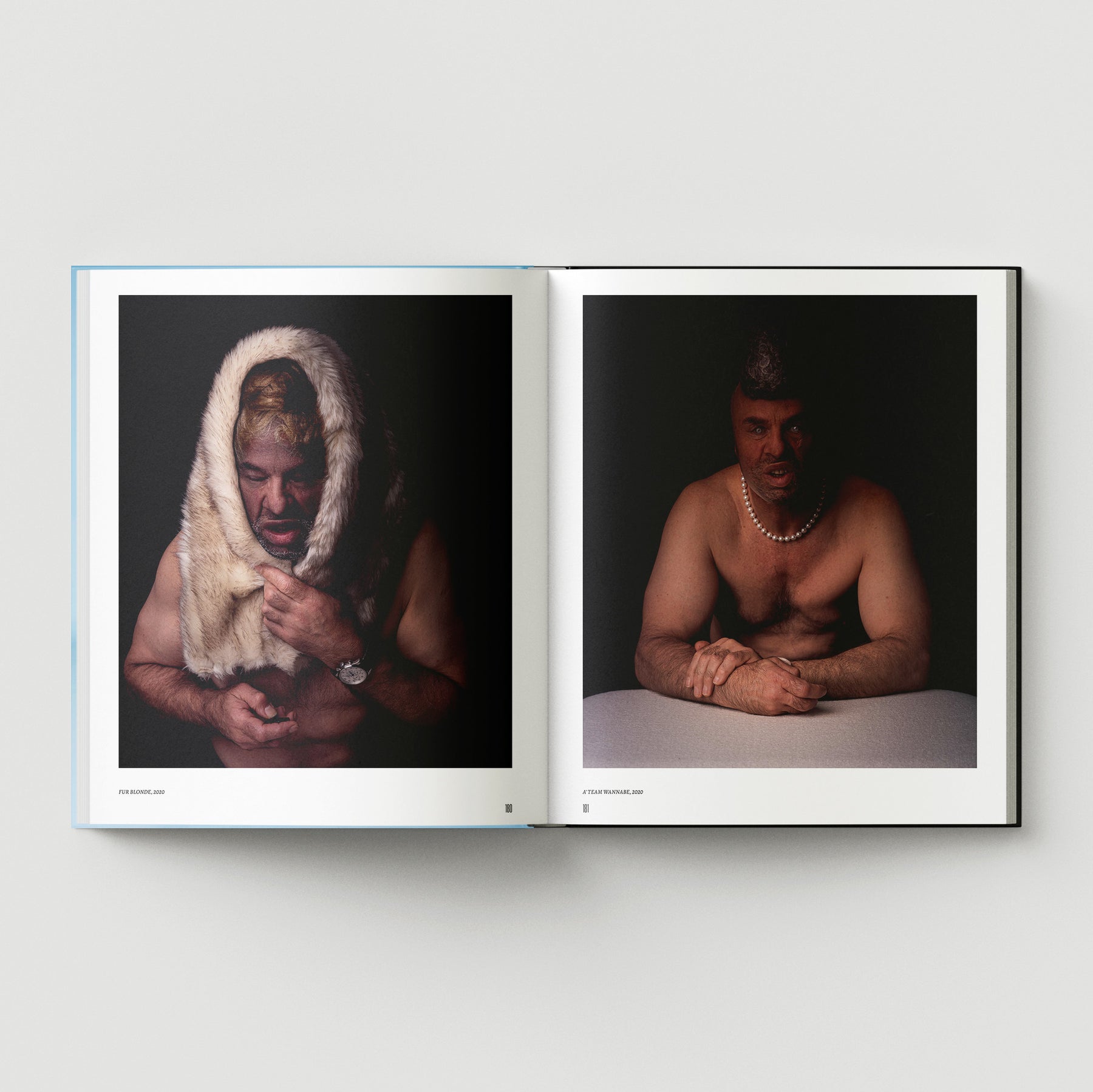 An open book, Formula + Fetish by Black Dog Press, displays two portraits: on the left, a shirtless man with fur over his head; on the right, he wears jewellery and a pearl necklace—both resting on a white surface.