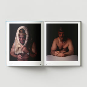 An open book, Formula + Fetish by Black Dog Press, displays two portraits: on the left, a shirtless man with fur over his head; on the right, he wears jewellery and a pearl necklace—both resting on a white surface.