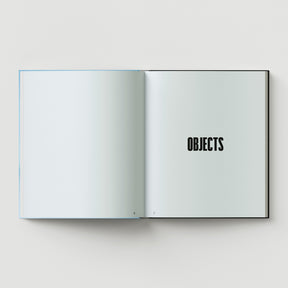 An open book displays two blank white pages; the right page shows "FORMULA + FETISH" in bold black, with page numbers 6 and 7 at the bottom—reflecting the minimalist style associated with Black Dog Press.